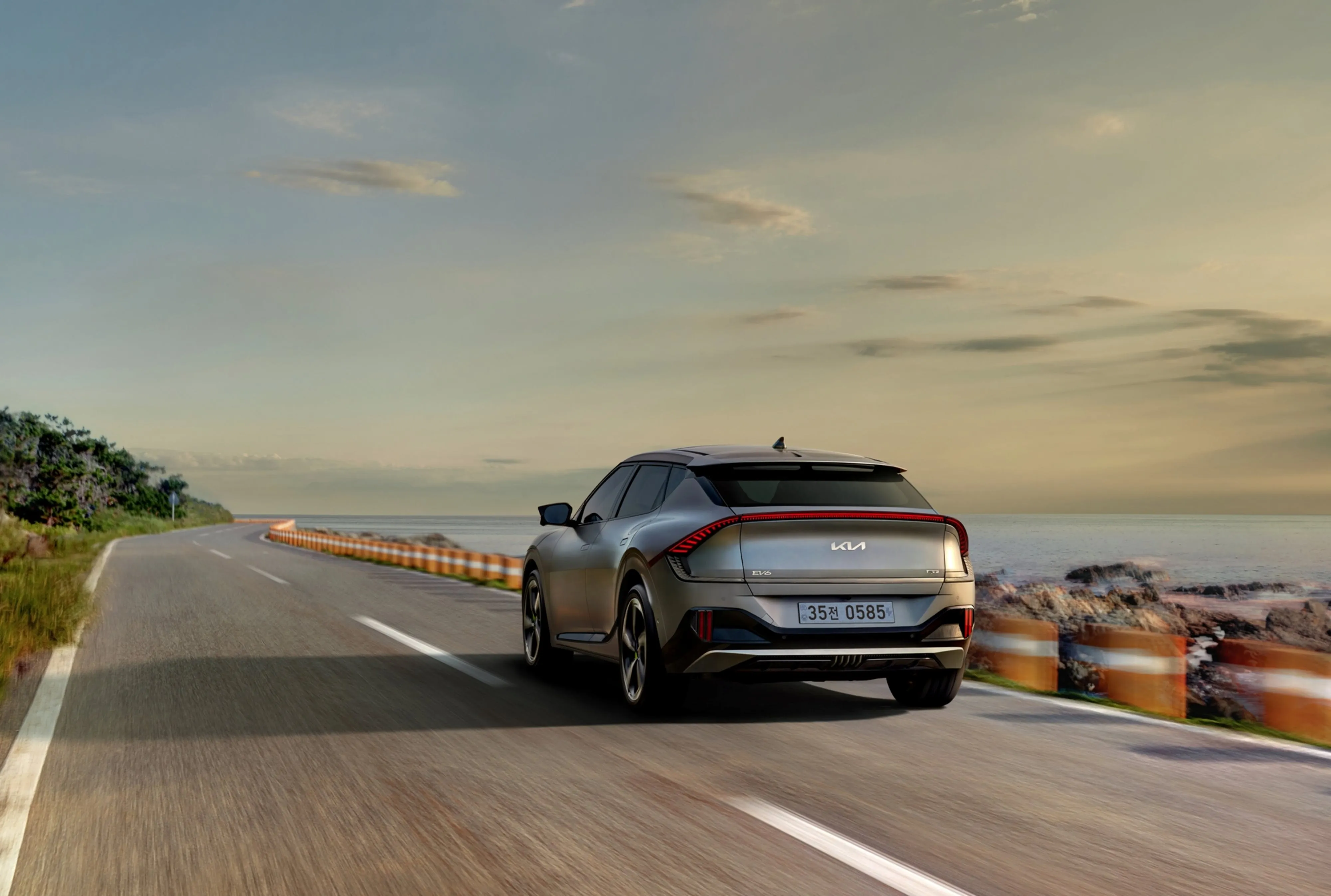 A Kia EV6 driving along a coastal road